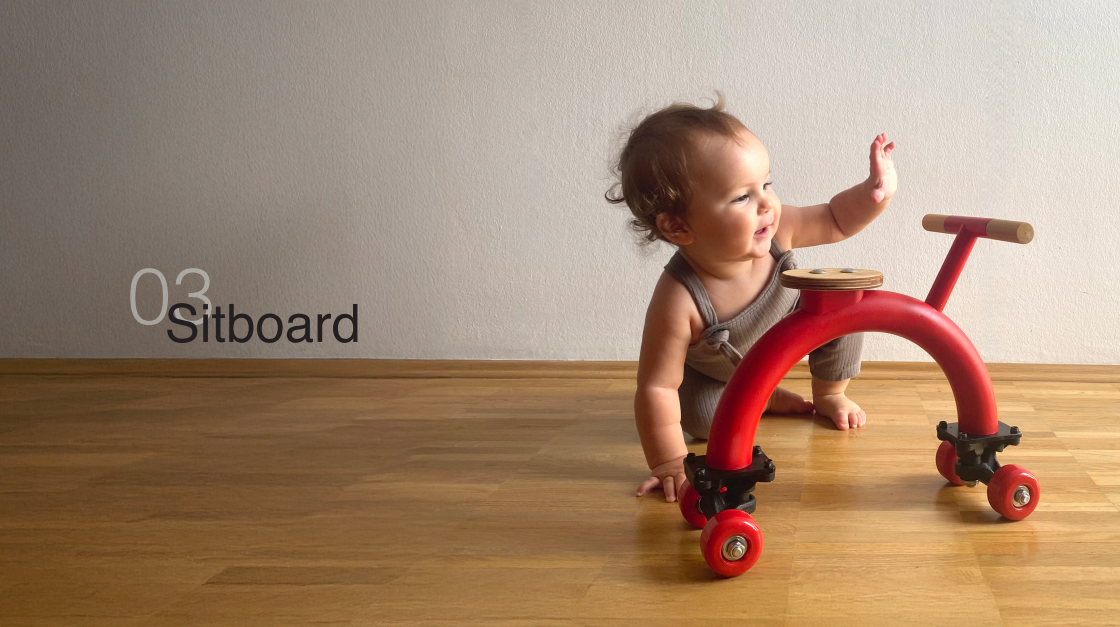 Ein Baby krabbelt auf ein rotes Sideboard-Rutschauto zu