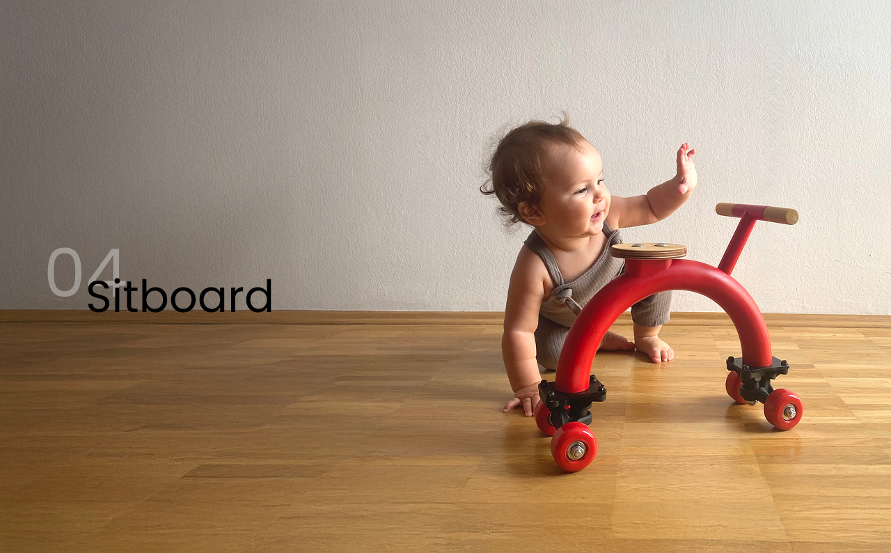 Ein Baby krabbelt auf ein rotes Sideboard-Rutschauto zu
